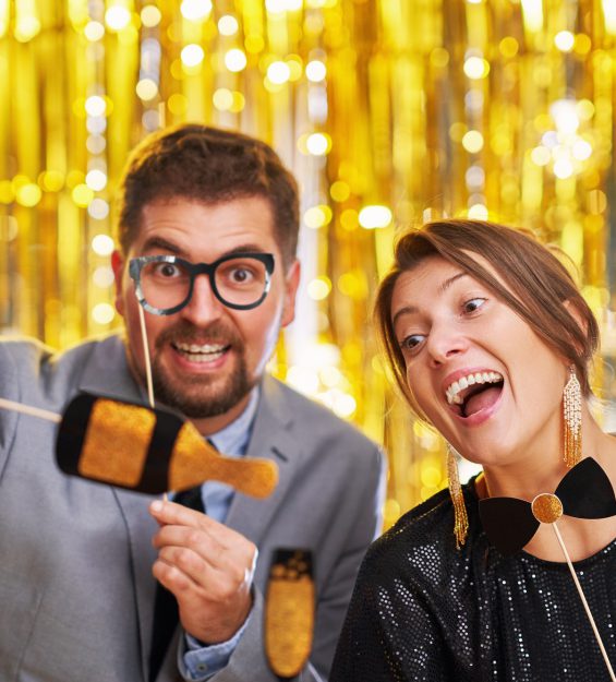 Couple over gold with photo booth accessories on party